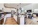 Modern kitchen with a large island, stainless steel appliances, sleek cabinetry, and a view of the living area at 2840 E 102Nd Pl, Thornton, CO 80229