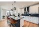 Bright kitchen with an island with bar seating, pendant lighting, and modern stainless steel appliances at 2840 E 102Nd Pl, Thornton, CO 80229