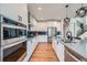 Contemporary kitchen features stainless appliances, sleek white cabinets and modern lighting fixtures at 2840 E 102Nd Pl, Thornton, CO 80229