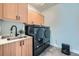 Functional laundry room with sink, storage cabinets, and modern washer/dryer at 2840 E 102Nd Pl, Thornton, CO 80229
