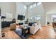 Bright living room featuring high ceilings, a fireplace, sleek furniture, and natural light at 2840 E 102Nd Pl, Thornton, CO 80229