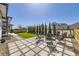 Backyard stone patio with pavers, fire pit, and landscaped yard at 2840 E 102Nd Pl, Thornton, CO 80229