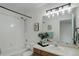Bright bathroom featuring a tub with shower, vanity, and modern lighting fixture at 4504 S Cimmarron Cir # D, Aurora, CO 80015