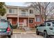 Exterior view of the townhome with balcony, red brick, siding, and street parking at 4504 S Cimmarron Cir # D, Aurora, CO 80015