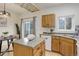 Cozy kitchen features wood cabinets, stainless sink, white appliances, and an island with matching countertop at 4504 S Cimmarron Cir # D, Aurora, CO 80015