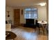 A cozy living and dining area with warm hardwood floors, a dark media center and dining table at 155 S Pennsylvania St # 209, Denver, CO 80209