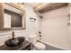 Modern bathroom featuring white subway tile, wood ceiling beam, and black vessel sink at 303 W Lehow Ave # 22, Englewood, CO 80110