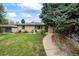 Charming single-story home featuring a well-manicured front yard, mature trees, and inviting curb appeal at 1217 Lincoln St, Longmont, CO 80501