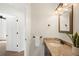 Bright bathroom featuring a vanity with granite counters, bronze hardware and fixtures, and decorative wall mirror at 3402 N Clayton St, Denver, CO 80205