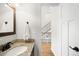 Half bath features granite countertop and view towards the stairs and second floor at 3402 N Clayton St, Denver, CO 80205