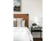 Cozy bedroom featuring a leather headboard, striped pillow, and stylish black nightstand with a table lamp at 3402 N Clayton St, Denver, CO 80205