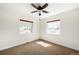 Sun-filled bedroom with two windows, neutral carpet, and a modern ceiling fan offering a simple and clean design at 3402 N Clayton St, Denver, CO 80205