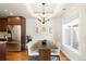 Bright dining area with hardwood floors, chandelier, adjacent stainless steel fridge and large window at 3402 N Clayton St, Denver, CO 80205