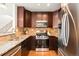 Well-equipped kitchen featuring stainless steel appliances, granite countertops, and ample dark wood cabinetry at 3402 N Clayton St, Denver, CO 80205