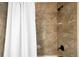 Close-up of a tiled shower stall with a white shower curtain and oil rubbed bronze shower head at 3402 N Clayton St, Denver, CO 80205