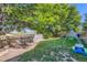 Large, grassy backyard with mature trees and swing set, perfect for recreation at 12 Apache Plume St, Brighton, CO 80601