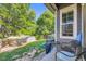 View of lush, fenced backyard from patio with seating and barbeque grill at 12 Apache Plume St, Brighton, CO 80601