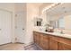 Well-lit bathroom with double sinks, a large mirror, and ample cabinet space for storage at 12 Apache Plume St, Brighton, CO 80601