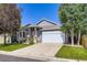 Home featuring a charming front yard, complemented by a well-kept lawn and an attached garage at 12 Apache Plume St, Brighton, CO 80601