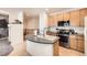 Kitchen island with updated appliances, cabinets, and tile flooring at 12 Apache Plume St, Brighton, CO 80601