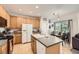 Well-lit kitchen with tile flooring, center island, and adjacent dining area at 12 Apache Plume St, Brighton, CO 80601