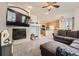 Open concept living room with fireplace, modern ceiling fan, and open access to the kitchen at 12 Apache Plume St, Brighton, CO 80601