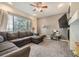 Cozy living room featuring a large sectional sofa, fireplace, and a ceiling fan at 12 Apache Plume St, Brighton, CO 80601