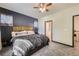 Comfortable main bedroom showcasing a ceiling fan, bedside table, and doorway leading to an en-suite bathroom at 12 Apache Plume St, Brighton, CO 80601