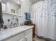 Bright bathroom with decorative mirror, white vanity and shower with curtain at 5006 S Nelson St # B, Littleton, CO 80127