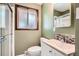 Bathroom featuring a shower, sliding glass door, window and vanity with decorative backsplash at 2692 S Osceola St, Denver, CO 80219