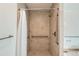 Neutral tiled walk-in shower featuring safety bars and curtain at 2692 S Osceola St, Denver, CO 80219