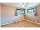 Comfortable bedroom featuring hardwood floors, a ceiling fan, and two windows with views of the outdoors at 2692 S Osceola St, Denver, CO 80219