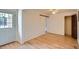 Bright bedroom featuring wood floors, a closet, and a white paneled door leading to the exterior at 2692 S Osceola St, Denver, CO 80219