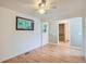Spacious bedroom with hardwood floors, neutral walls, and a window above a framed mirror at 2692 S Osceola St, Denver, CO 80219