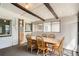 Enclosed dining room featuring exposed wood beams, neutral walls, and a large dining table with six chairs at 2692 S Osceola St, Denver, CO 80219