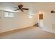 Large carpeted living room featuring a ceiling fan and staircase at 2692 S Osceola St, Denver, CO 80219