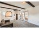 Open living space featuring exposed wood beams and access to a bright sunroom at 2692 S Osceola St, Denver, CO 80219
