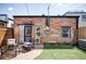 Cozy backyard featuring brick, partial artifical turf, outdoor seating and a hot tub on the right at 3733 N Franklin St, Denver, CO 80205