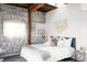 Serene bedroom with exposed brick, a comfortable bed with plush pillows, and modern decor at 3733 N Franklin St, Denver, CO 80205
