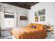 Inviting bedroom featuring exposed brick, decorative artwork, and a cozy bed with orange bedding at 3733 N Franklin St, Denver, CO 80205