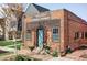 Charming brick building featuring 'Railroad Overall Laundry' signage, modern wood accents, and a vibrant blue door at 3733 N Franklin St, Denver, CO 80205