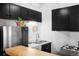Functional kitchen featuring black cabinets, stainless steel refrigerator and a double basin sink at 3733 N Franklin St, Denver, CO 80205