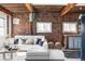 Inviting living room featuring exposed brick walls, wooden beams, and a stylish white sectional sofa at 3733 N Franklin St, Denver, CO 80205