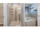 Bathroom with stand-up shower, bathtub, and bright vanity lights at 1694 Jennifer St, Brighton, CO 80601
