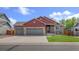 Charming two-story home featuring a three-car garage and well-maintained front yard at 1694 Jennifer St, Brighton, CO 80601