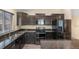 Modern kitchen with dark cabinets, granite countertops, and stainless steel appliances at 1694 Jennifer St, Brighton, CO 80601