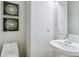 Powder room featuring a pedestal sink, toilet, and decorative art at 4181 W 118Th Pl, Westminster, CO 80031