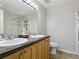 Bathroom featuring a double vanity with granite countertops, a large mirror, and a glass shower at 4181 W 118Th Pl, Westminster, CO 80031