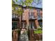 Brick townhome featuring balconies, a well-kept lawn, front gate, and potted plants at 4181 W 118Th Pl, Westminster, CO 80031