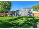 Expansive backyard featuring lush green grass, mature trees, and a privacy fence at 19523 E Buchanan Pl, Aurora, CO 80011
